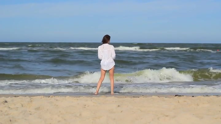 Girl At The Beach Walking Through Sea Water