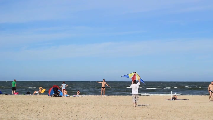 Guys Practicing With A Kite On A Beach